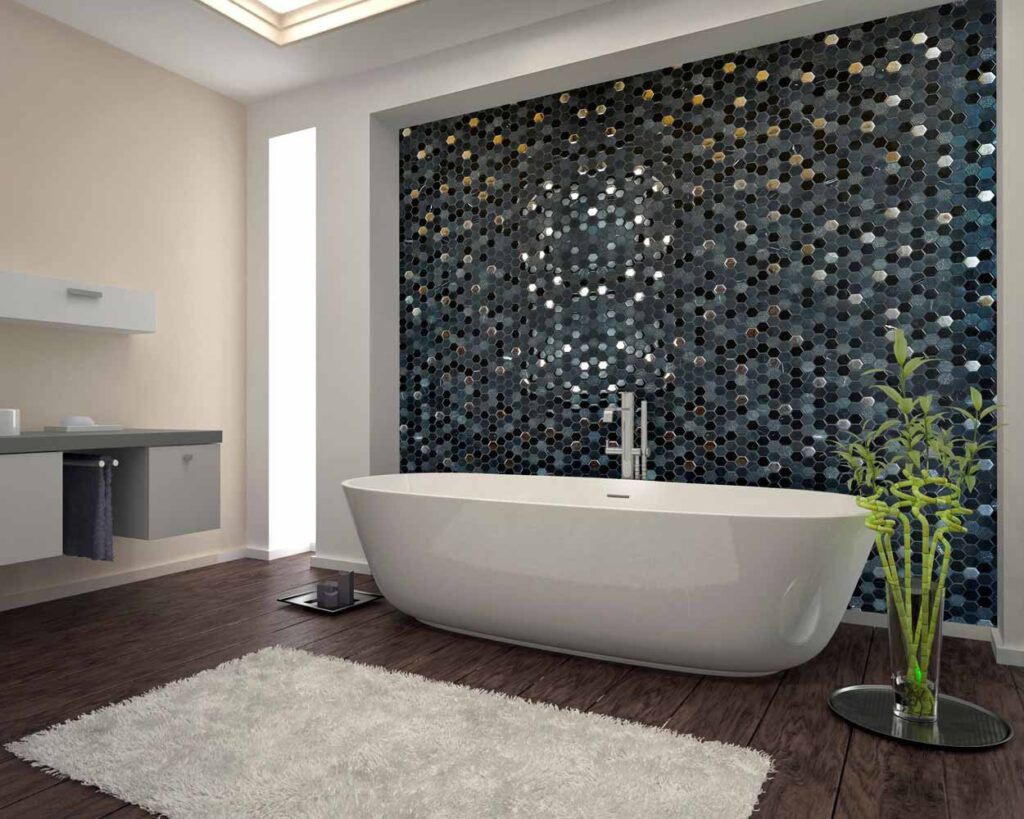 Modern bathroom featuring a sleek freestanding bathtub against a stylish hexagonal tile wall, complemented by a wooden floor and a decorative plant in a glass vase. Soft lighting enhances the contemporary design aesthetics.
