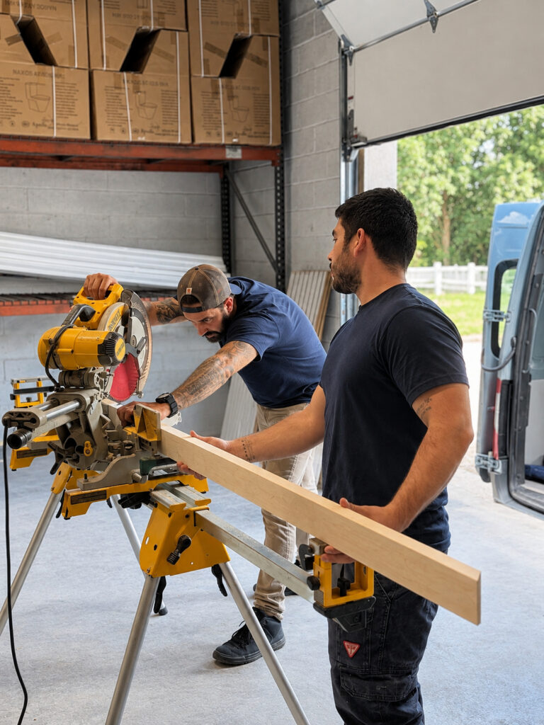 D&V Home Design Center craftsmen cutting trim on a miter saw in the company workshop